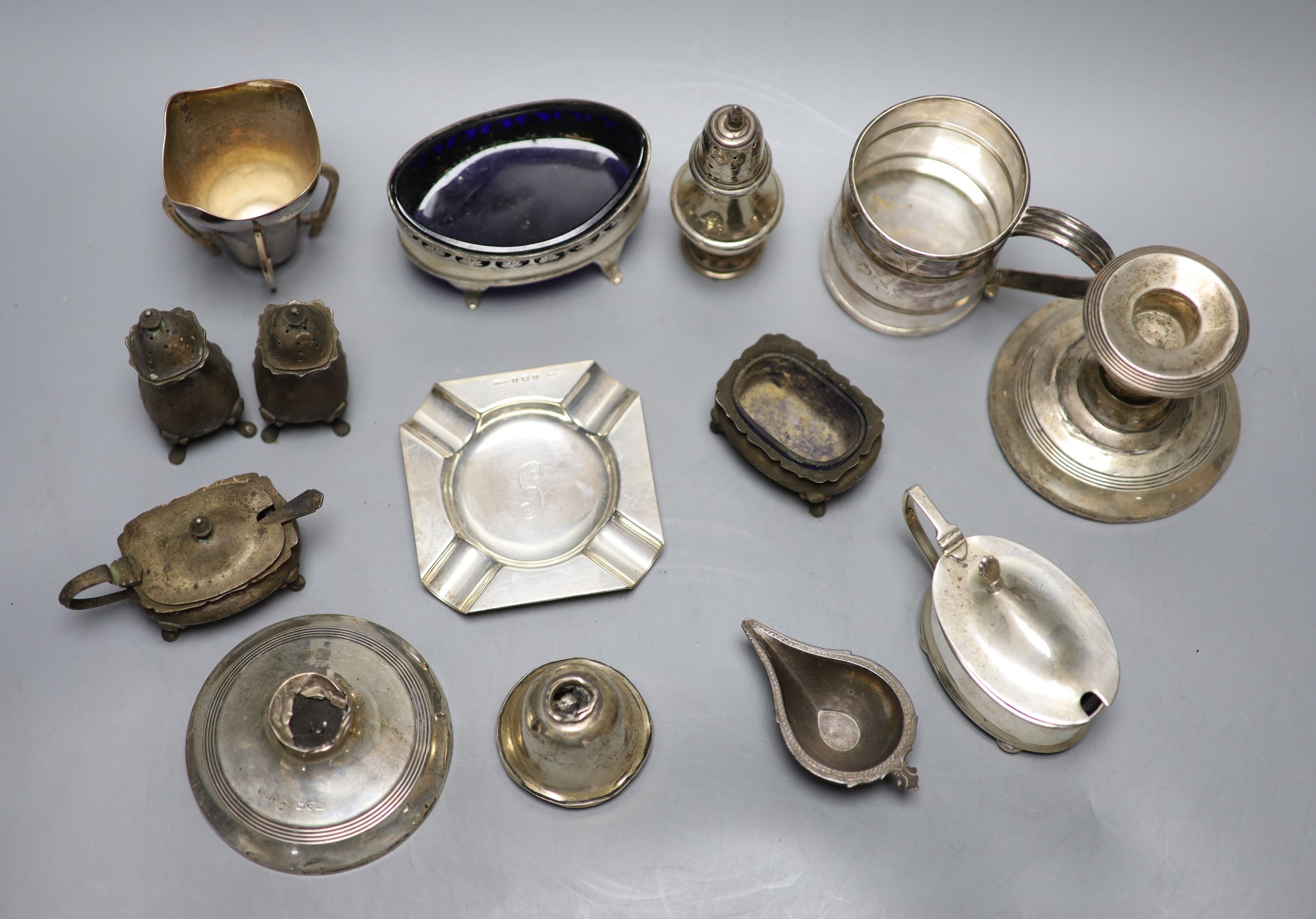 A mixed group of sundry small silver and other items including a pair of silver ashtrays, a small silver vase, silver pepper, damaged dwarf candlesticks, plated mug etc.